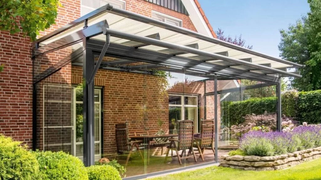 Zastínění zimní zahrady, šedá konstrukce na cihlovém domě - ilustrační článek k článku na téma Výběr markýz proti děšti na Jaktovybrat.cz