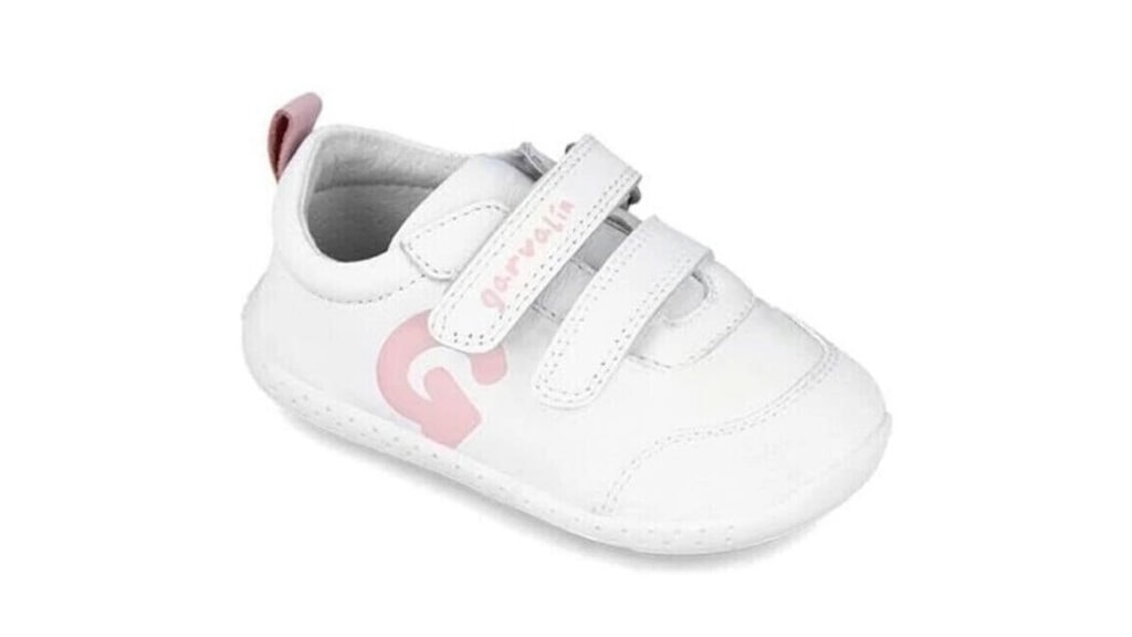 Bílé dětské barefoot boty Primigi s růžovým logem na boku a dvěma suchými zipy, vhodné pro první krůčky.