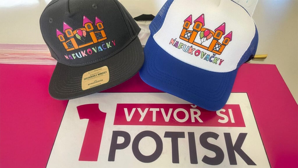 Barevně potištěné kšiltovky s logem „Nafukovačky“ – branding formou reklamního textilu vytištěného na zakázku.